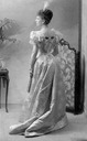 Mary possibly when still Princess May of Teck, showing a back view with her wearing an elegant evening dress and holding a fan in the 1890's