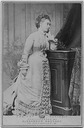 1875 Princess Alice standing wearing a bustle dress by desk, also by Alexander Bassano